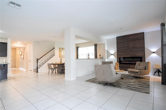 living room with a fireplace and light tile patterned floors