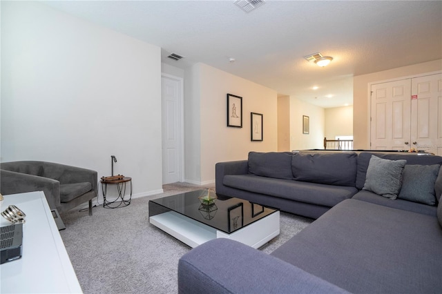 living room with a textured ceiling and light carpet