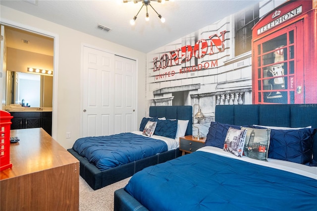 carpeted bedroom featuring a closet, lofted ceiling, and ensuite bathroom