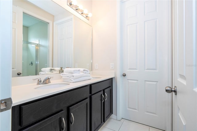 bathroom featuring walk in shower, vanity, and tile patterned flooring