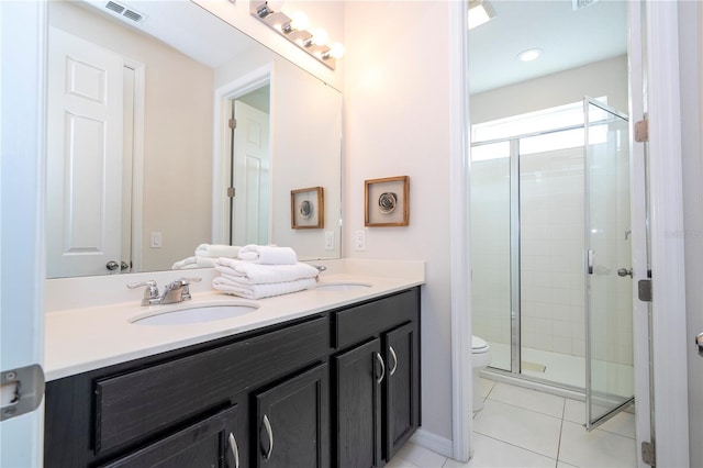 bathroom with vanity, walk in shower, tile patterned floors, and toilet