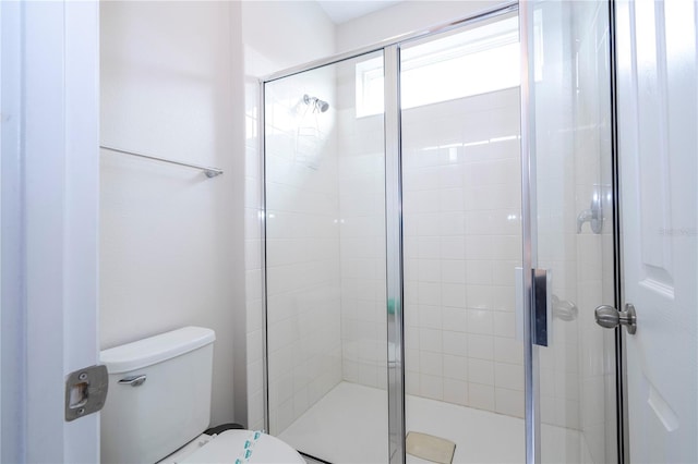 bathroom featuring toilet and an enclosed shower