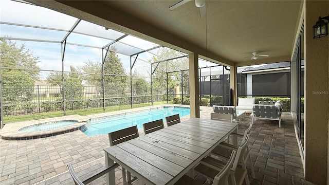 view of pool with a lanai, ceiling fan, a patio, and an in ground hot tub