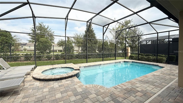 view of pool featuring glass enclosure, a patio, and an in ground hot tub