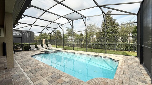 view of pool featuring glass enclosure, a patio area, and an in ground hot tub