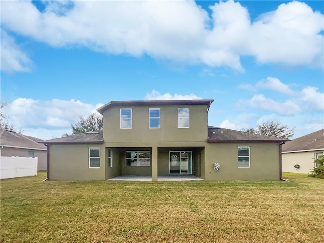 back of property featuring a patio area and a lawn