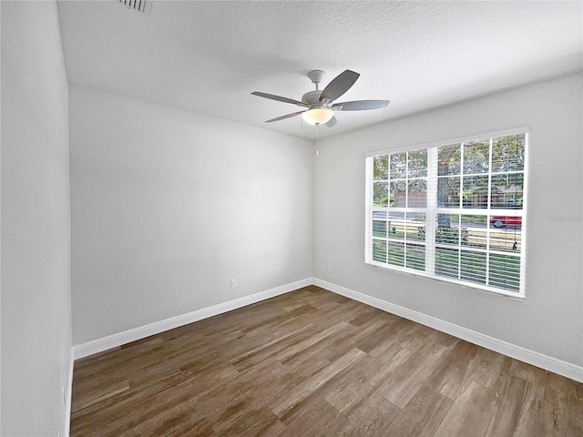 empty room featuring hardwood / wood-style floors, a textured ceiling, and ceiling fan