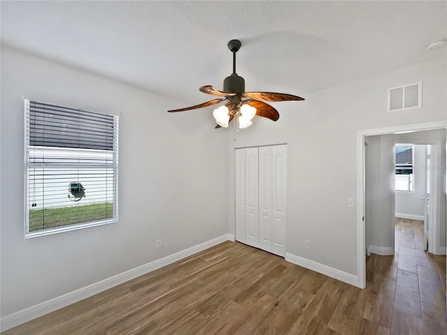 unfurnished bedroom with hardwood / wood-style flooring, a closet, and ceiling fan