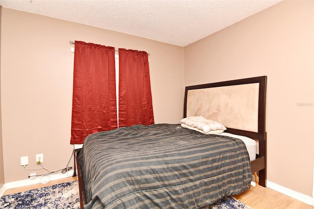 bedroom featuring a textured ceiling and wood-type flooring