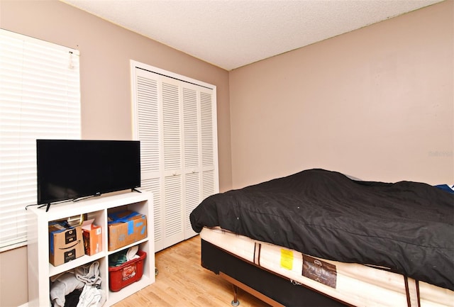 bedroom featuring a closet, a textured ceiling, and light wood-type flooring