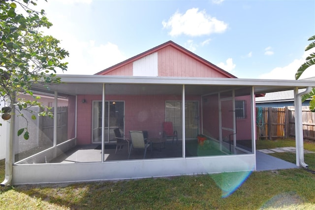 rear view of house featuring a yard and a sunroom