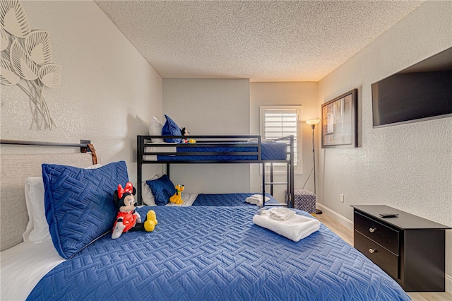 bedroom with a textured ceiling and hardwood / wood-style flooring