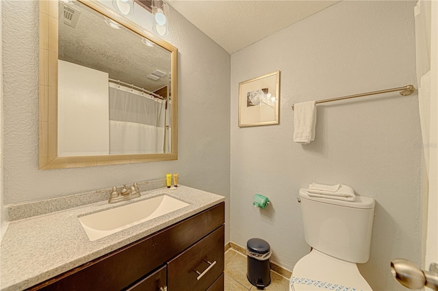 bathroom featuring tile patterned flooring, vanity, toilet, and a textured ceiling