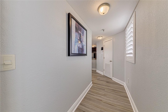 corridor with light hardwood / wood-style floors