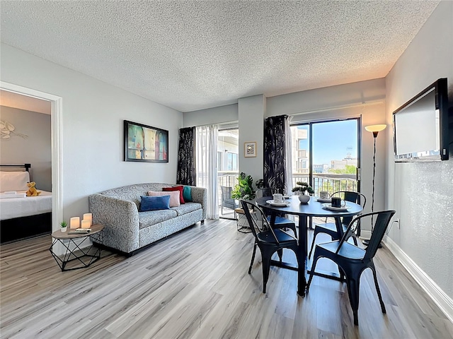 dining area with a textured ceiling, wood finished floors, and baseboards
