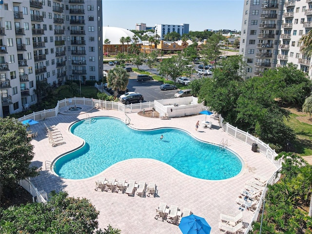 pool with a patio area and fence