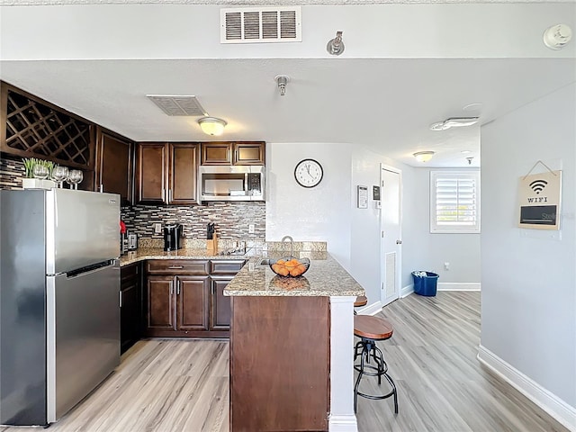kitchen featuring light wood finished floors, visible vents, and appliances with stainless steel finishes