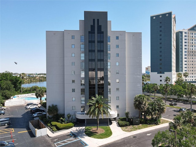 view of property featuring a water view and uncovered parking