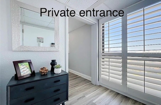 doorway to outside with light wood-style floors and baseboards
