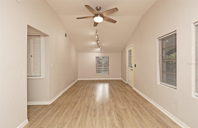 empty room featuring light hardwood / wood-style flooring, lofted ceiling, and ceiling fan