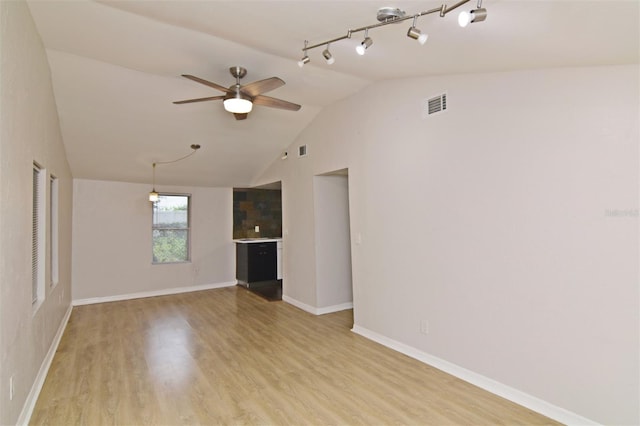 spare room with light hardwood / wood-style flooring, ceiling fan, track lighting, and vaulted ceiling