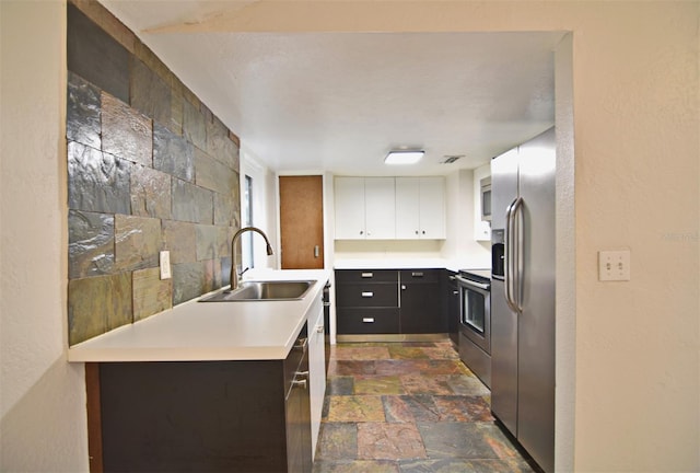 kitchen with appliances with stainless steel finishes, white cabinets, and sink