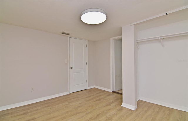 unfurnished bedroom with a closet and light wood-type flooring