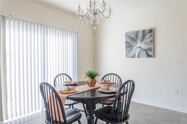 dining space with tile patterned flooring, plenty of natural light, and an inviting chandelier