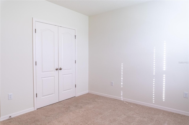 unfurnished bedroom featuring light carpet