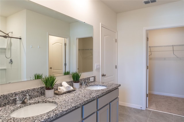 bathroom featuring vanity, a shower with door, and tile patterned flooring