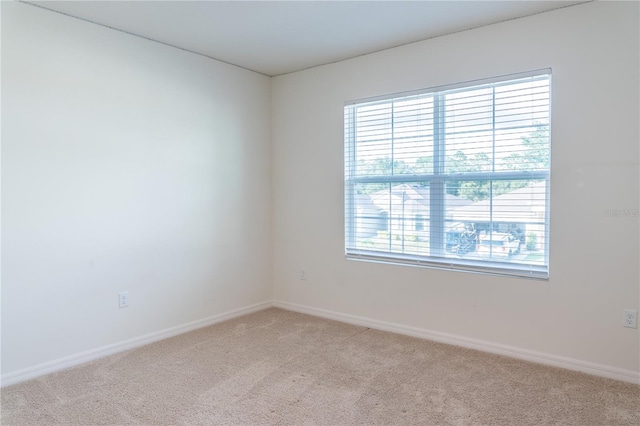 unfurnished room featuring light carpet