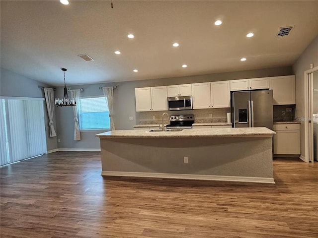 kitchen featuring light hardwood / wood-style flooring, stainless steel appliances, and a center island with sink