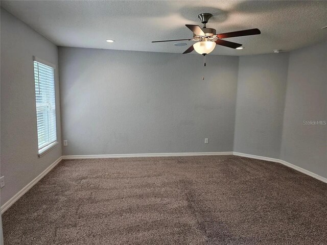 spare room featuring a textured ceiling, carpet floors, and ceiling fan