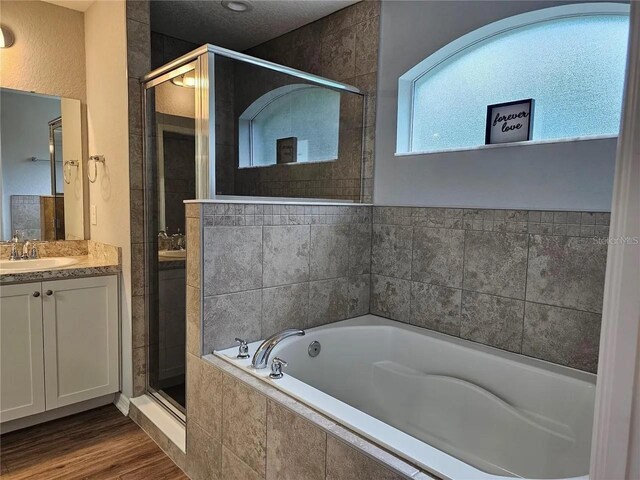 bathroom featuring vanity, hardwood / wood-style flooring, and separate shower and tub