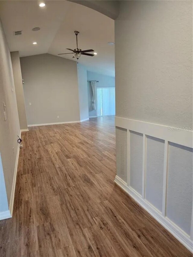 unfurnished room with ceiling fan, vaulted ceiling, and hardwood / wood-style floors