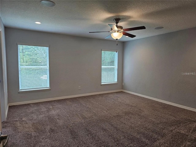 carpeted empty room featuring a textured ceiling, a healthy amount of sunlight, and ceiling fan