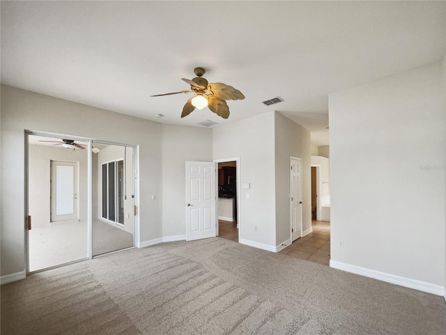 carpeted spare room with ceiling fan