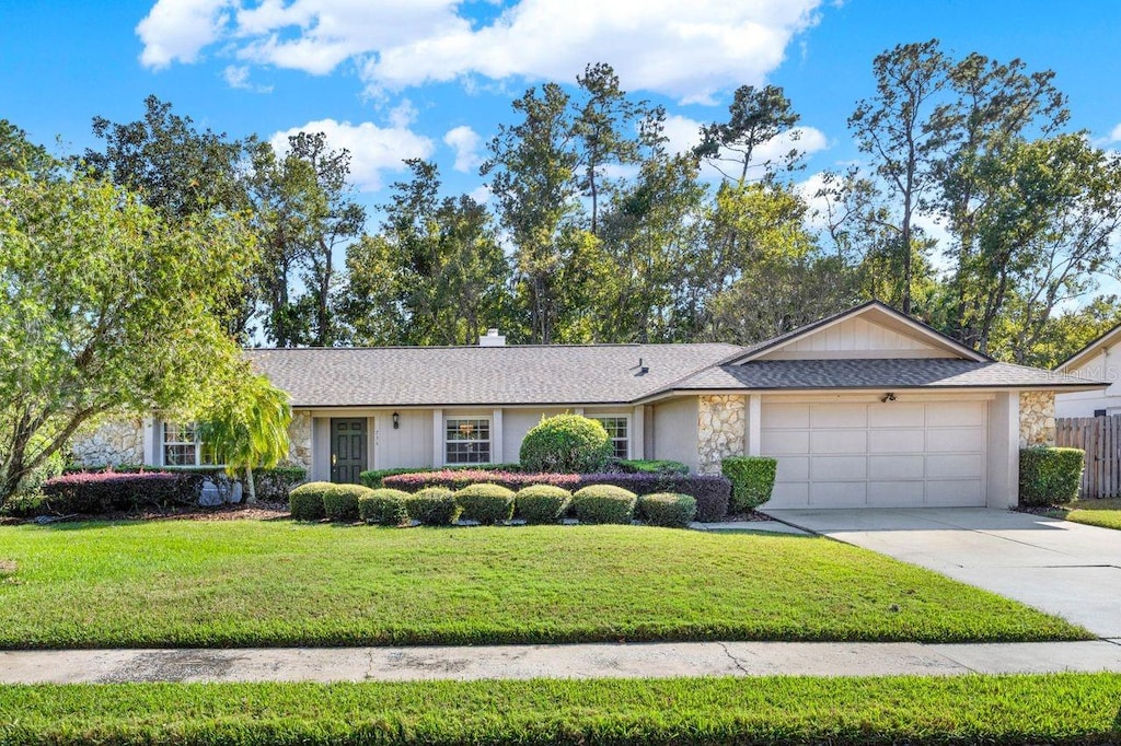 single story home with a front yard and a garage