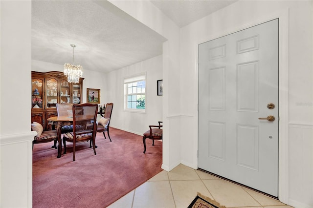 734 Riverbend Blvd, Longwood, FL 32779 - foyer with light colored carpet, a chandelier, a textured ceiling, light tile patterned floors, and baseboards