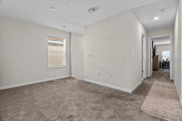 empty room with a textured ceiling and carpet