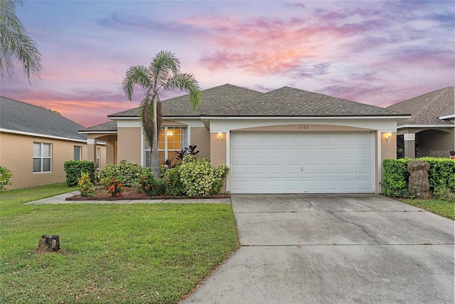 view of front of home with a garage and a lawn