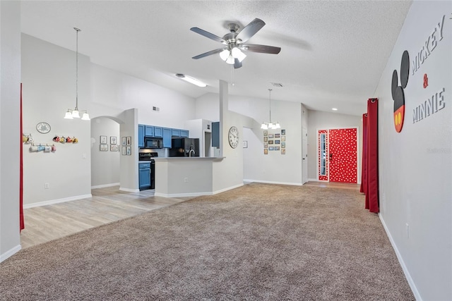 unfurnished living room with high vaulted ceiling, a textured ceiling, light wood-type flooring, and ceiling fan with notable chandelier