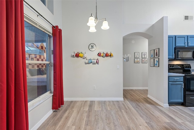 unfurnished dining area with a notable chandelier and light wood-type flooring