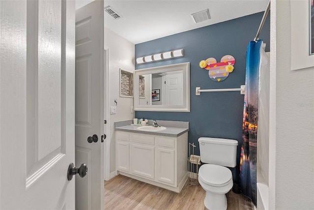 full bathroom featuring vanity, toilet, shower / bath combo with shower curtain, and hardwood / wood-style floors