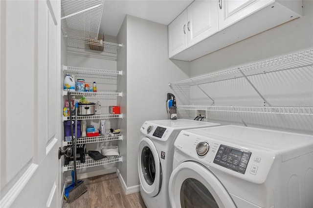 laundry room featuring cabinets, washer and clothes dryer, and light wood-type flooring