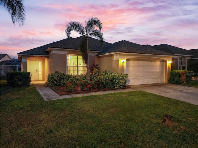 view of front of home with a yard and a garage