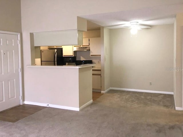 kitchen featuring kitchen peninsula, white cabinets, ceiling fan, stainless steel refrigerator, and carpet floors