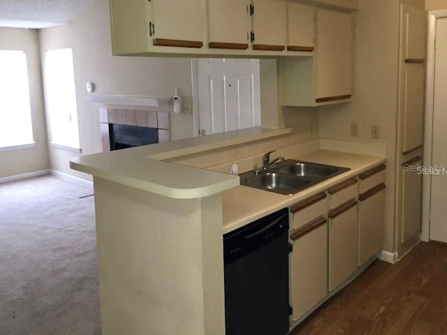 kitchen with black dishwasher, sink, kitchen peninsula, and cream cabinetry