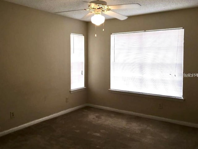 carpeted spare room featuring ceiling fan, a healthy amount of sunlight, and a textured ceiling