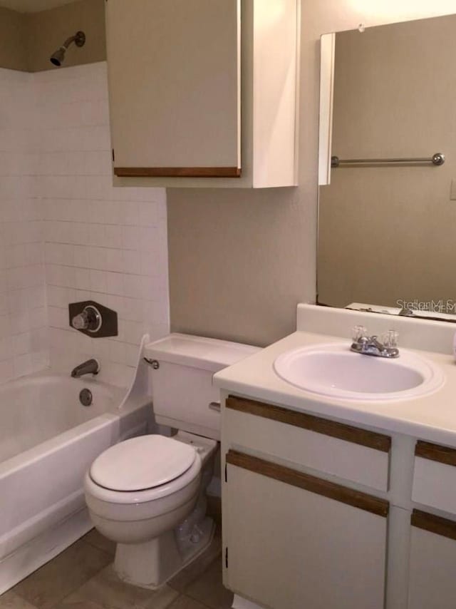 full bathroom featuring vanity, tiled shower / bath combo, toilet, and tile patterned flooring